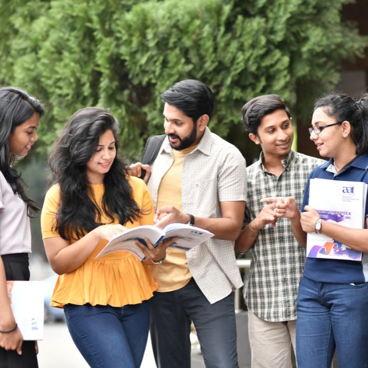 Diverse students collaborating on a book, a scene from campus life arranged by Study Abroad agencies in Kerala.